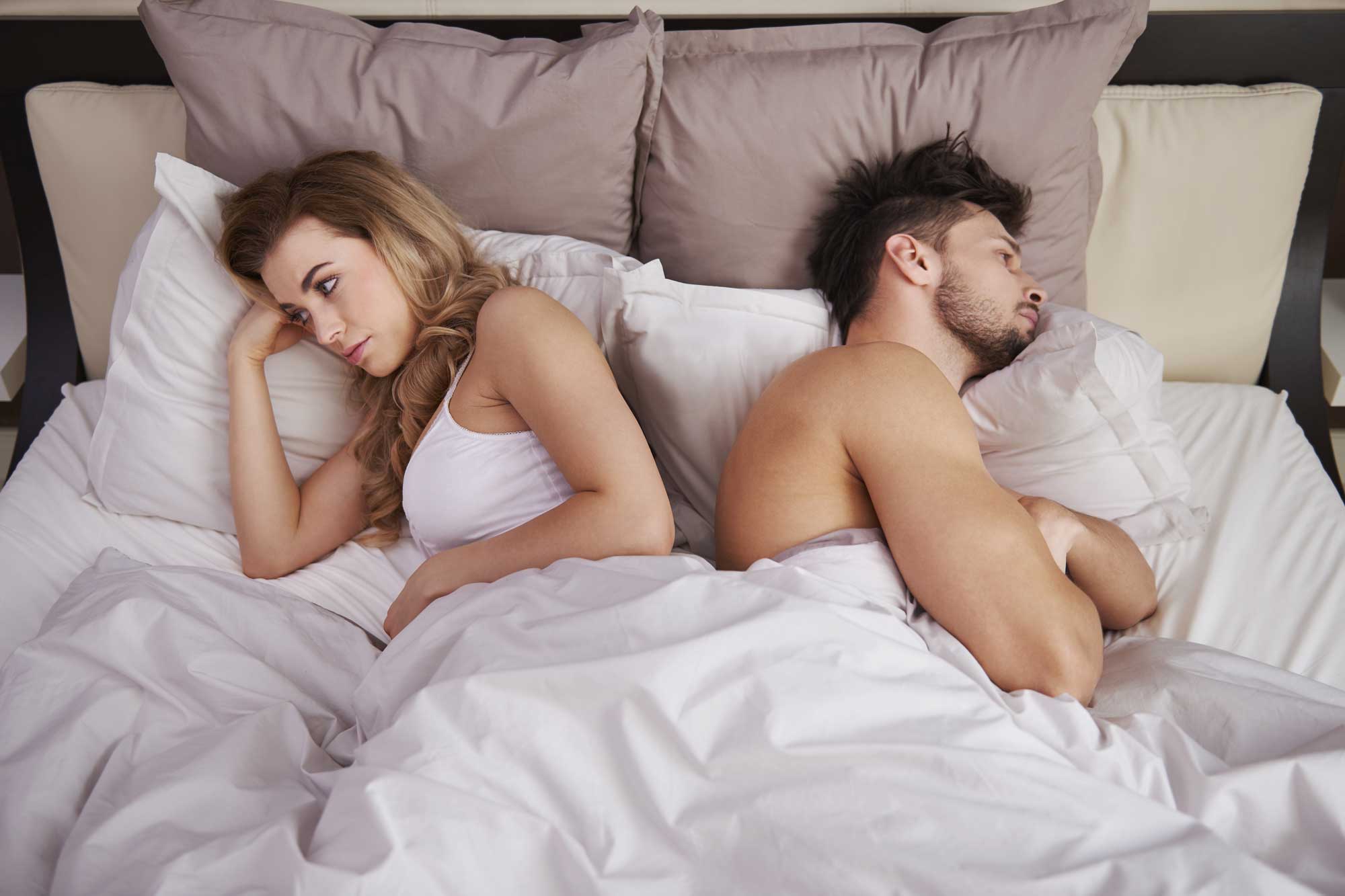 couple upset laying in bed